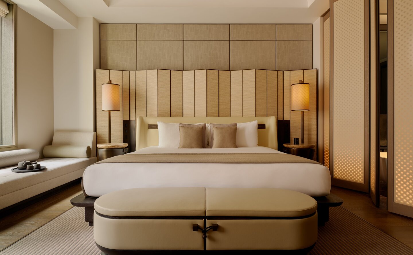Grand Suite principal bedroom at Aman New York, featuring a neutral colour palette with wood panelling and soft lighting.