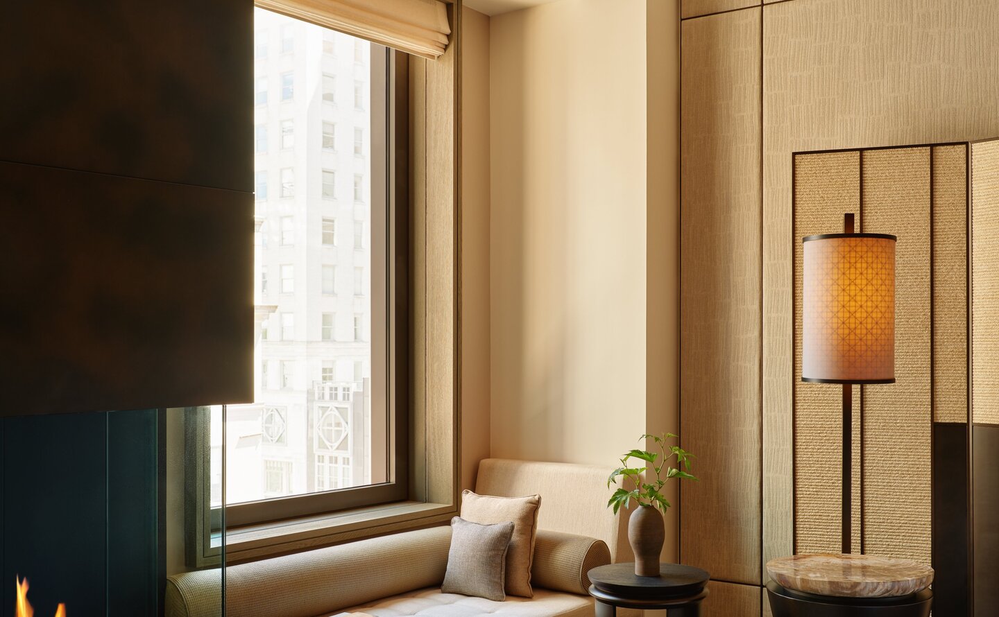 Premier Suite with window seating area at Aman New York, featuring neutral tones and contemporary design.
