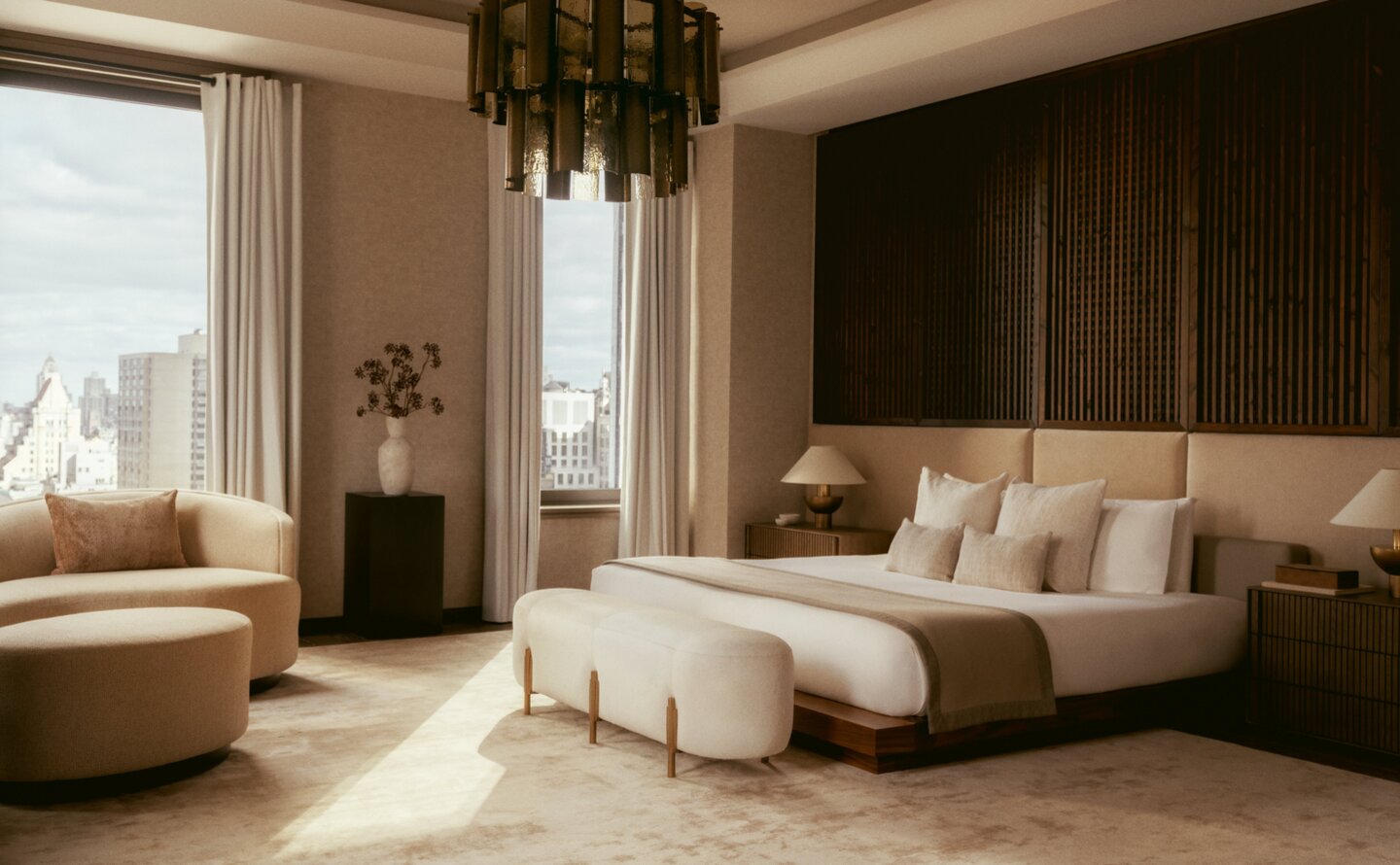 Principal bedroom with neutral tones and floor-to-ceiling windows overlooking New York City at Aman New York.