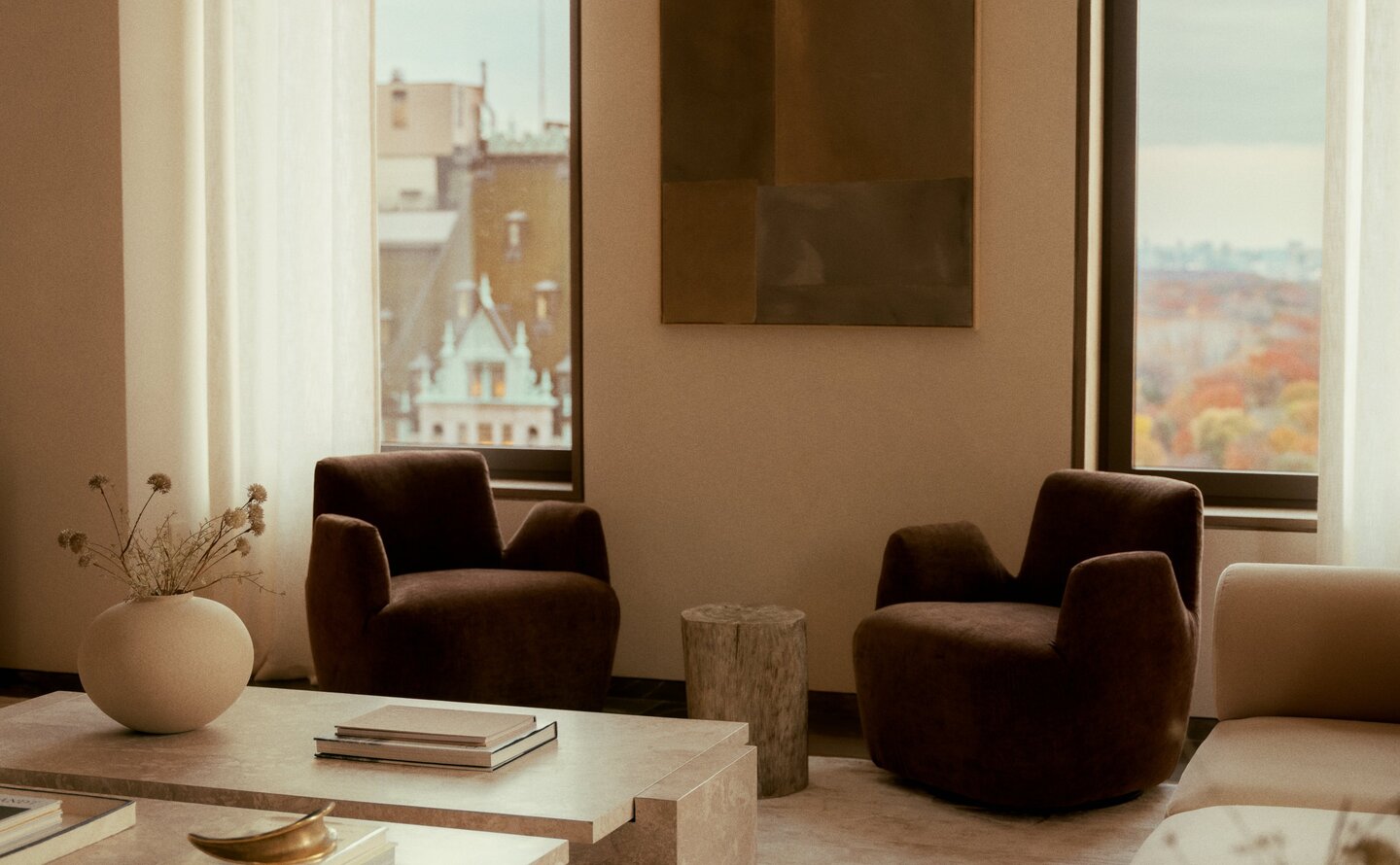 Aman New York three-bedroom penthouse living room with floor-to-ceiling windows, leather seating, and neutral tones.
