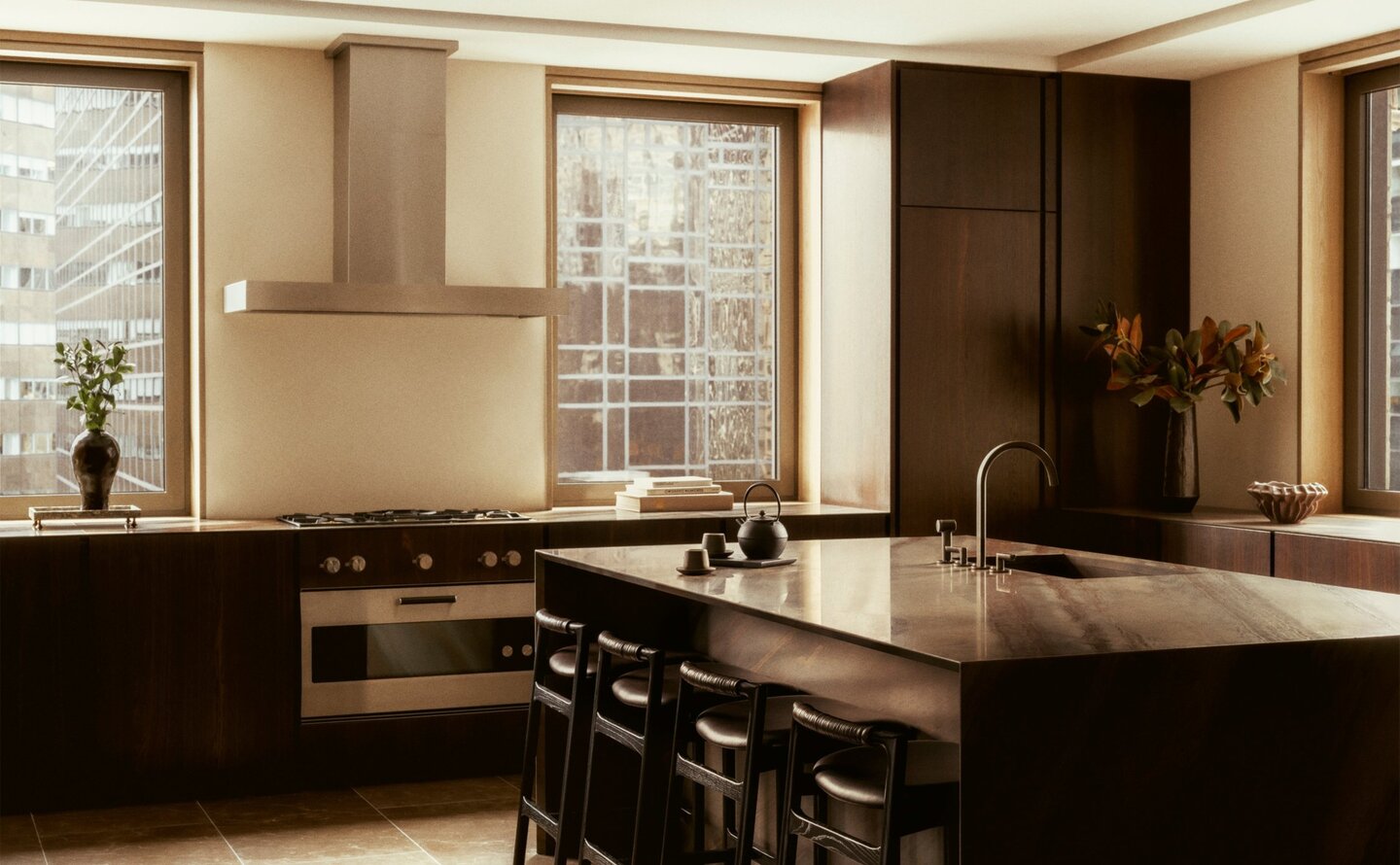Penthouse kitchen with dark cabinetry, wooden accents, and bar seating at Aman New York.