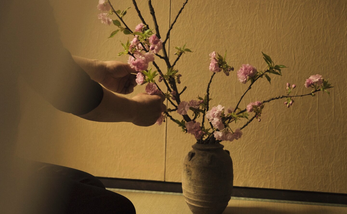 Ikebana arrangement with delicate branches in dark ceramic vessel at Aman New York.
