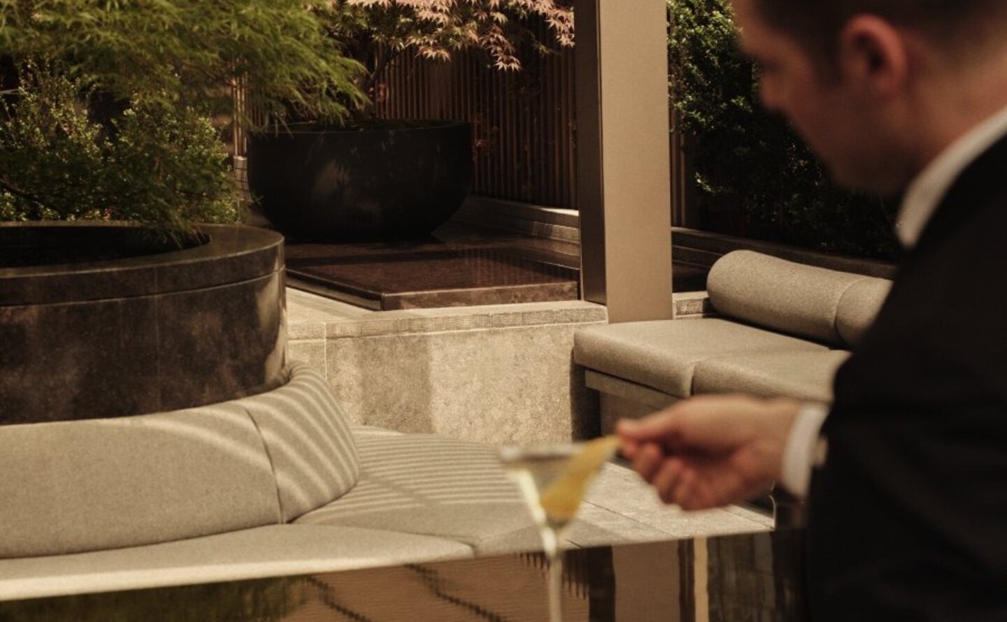 Man reviewing plans on terrace at Aman New York with city views beyond.