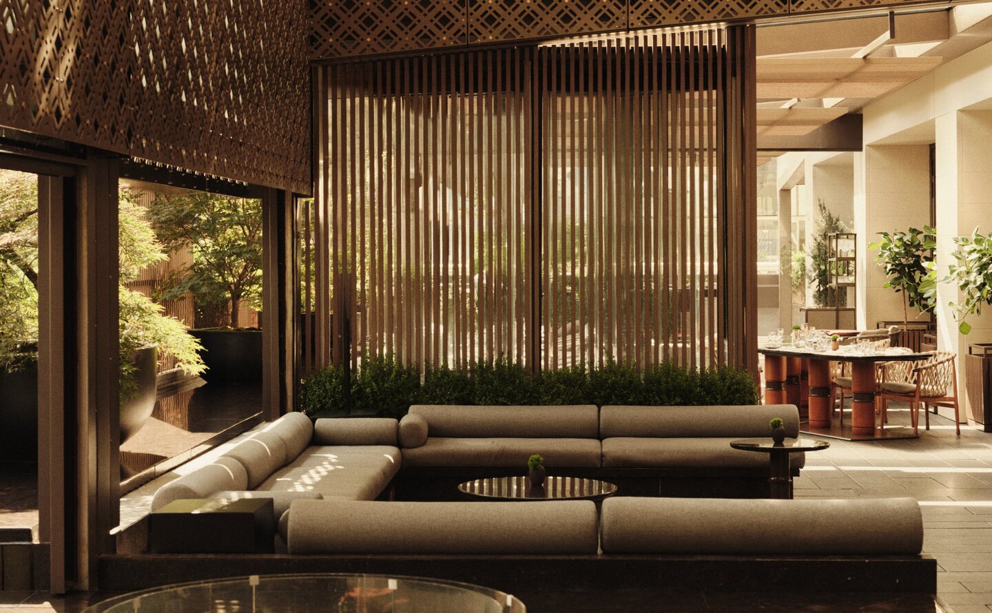 Terrace at Aman New York with wooden screens, low seating, and fireplace glowing at dusk.