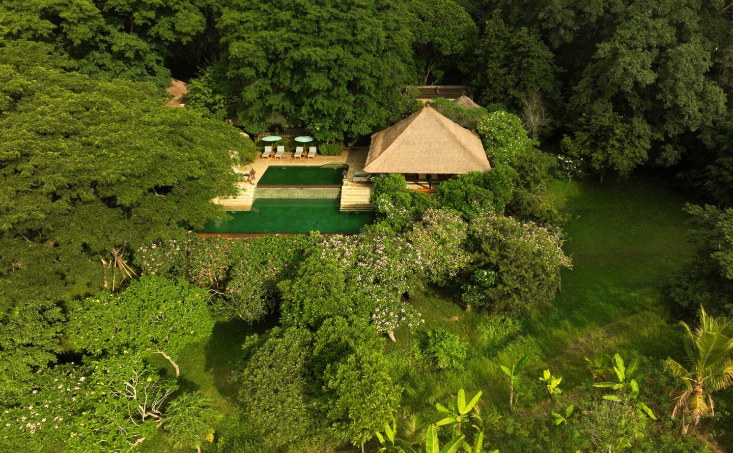 Aerial view of a three-bedroom villa at Amandari surrounded by lush green rice terraces in Indonesia.