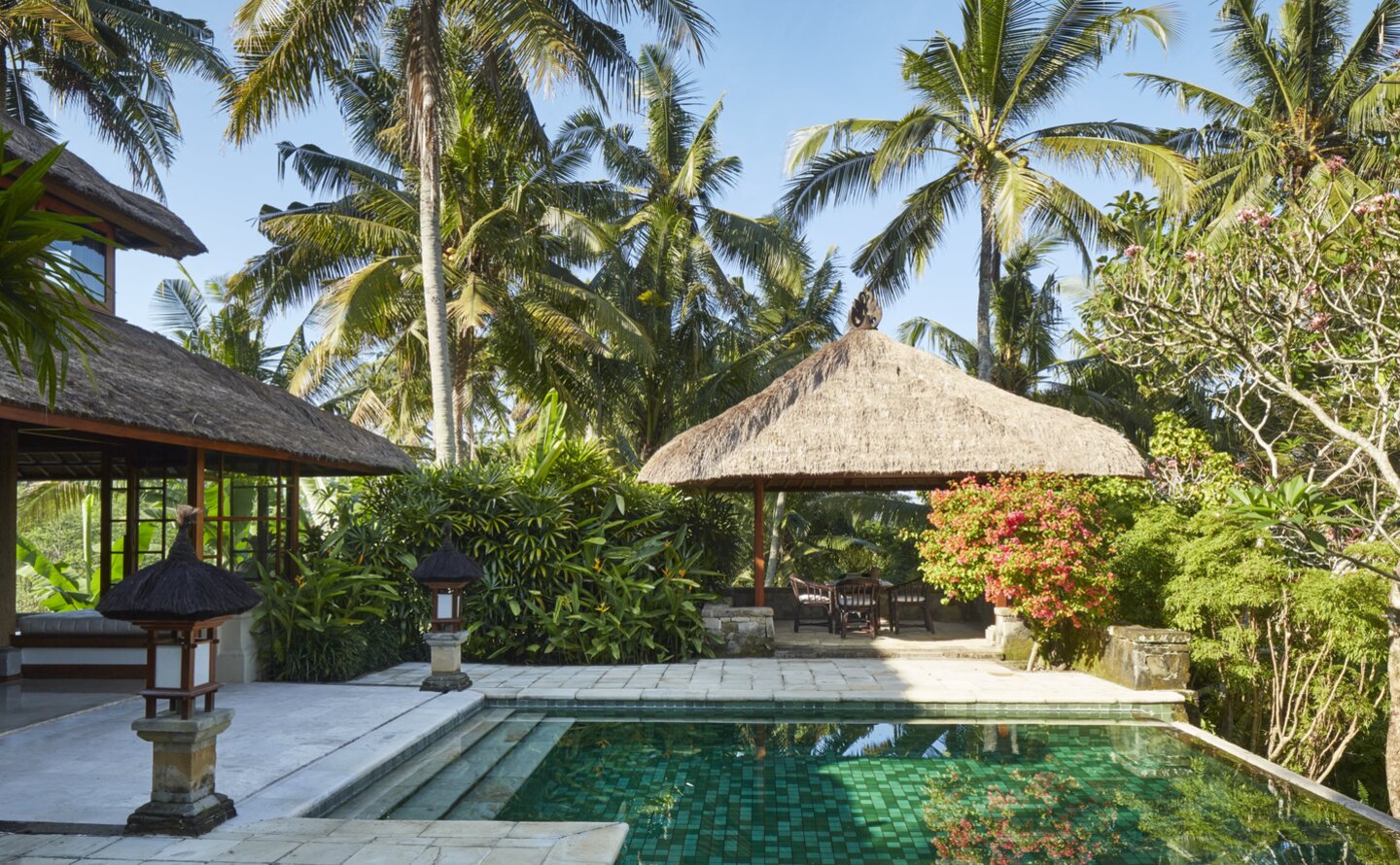 Duplex pool villa at Amandari with swimming pool surrounded by tropical gardens and palm trees, Indonesia.