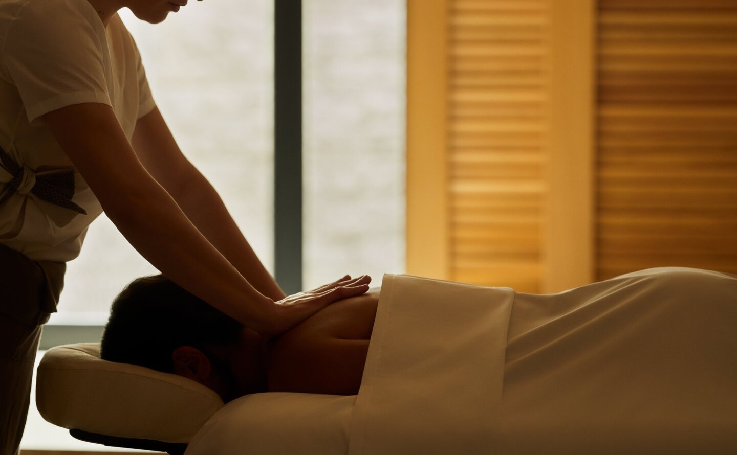 Therapist administering a wellness treatment at Amanzoe spa in Greece.