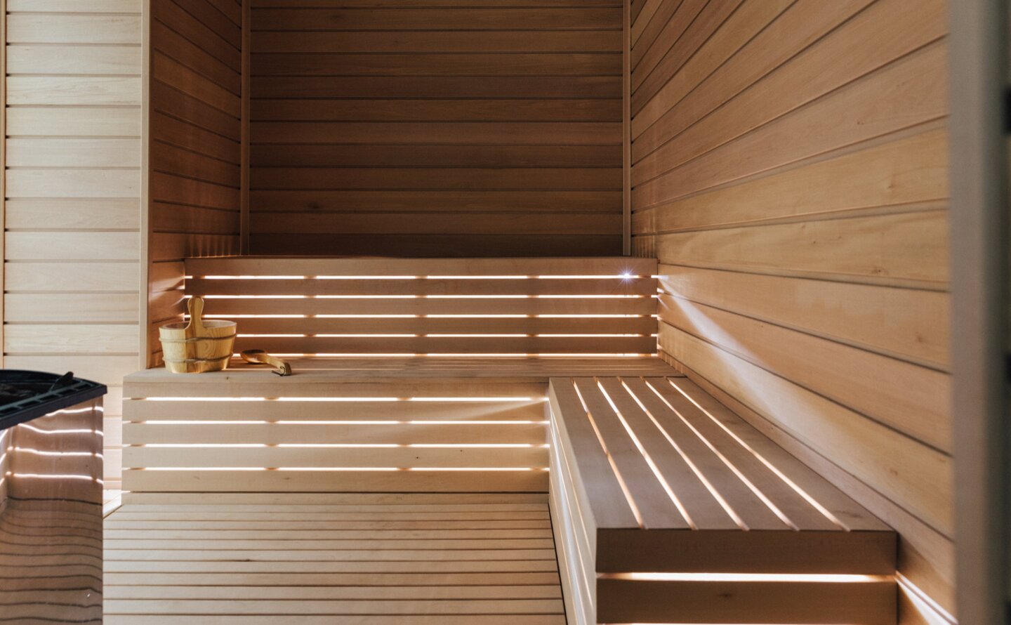 Wooden sauna interior at Amanzoe with tiered benches and warm lighting.