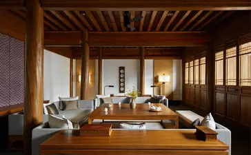 Wooden interior space at Amandayan with desk, chair and latticed windows allowing natural light.
