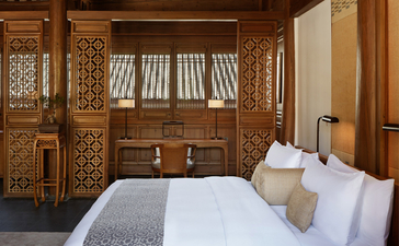 Principal bedroom at Amandayan with carved wooden panelling and traditional furnishings.