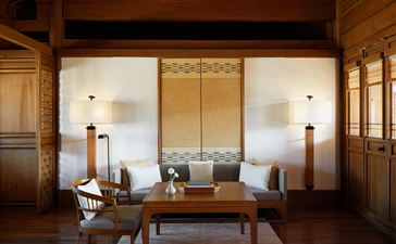 Serene sitting area at Amandayan with symmetrical seating, wooden screens, and warm lighting.