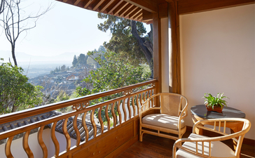 大研安缦度假村的景观阳台，木质栏杆框绕山景视野，配有舒适座椅。