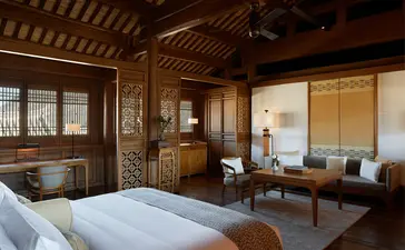 Amandayan principal bedroom with wooden furnishings, traditional architecture, and serene neutral tones.