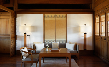 大研安缦度假村的宽敞客厅，木质地板和传统装饰营造宁静氛围。