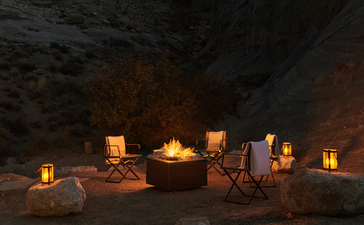 Candlelit gathering in a desert cave alcove at Amangiri resort, with warm lanterns casting shadows on stone walls.