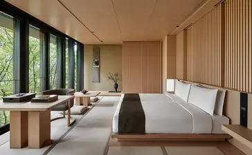 安缦京都度假村的宽敞卧室，配有榻榻米垫地板、木制家具及落地窗，景观优美。