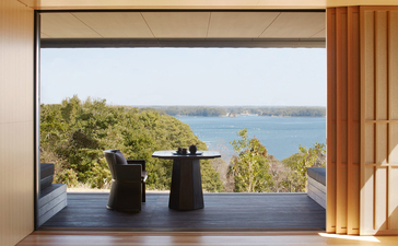 Vue sur la baie depuis une chambre d'Amanemu, avec trois vases noirs sur le rebord de la fenêtre.