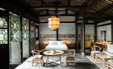 法云安缦度假村的用餐空间，配备现代吊灯、木质家具和传统中式窗户设计。