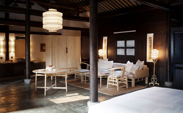Amanfayun's open-plan living area with dining table, seating spaces, and warm pendant lighting.
