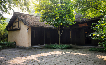 法云安缦度假村的传统建筑，米色墙壁、深色木质门窗，周围绿树环绕。