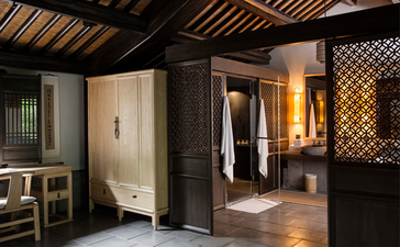 Spa treatment room at Amanfayun with wooden screens, illuminated alcove and changing facilities.