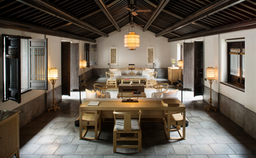 Amanfayun dining room with wooden table, contemporary furnishings and neutral tones.