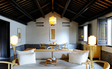 Amanfayun spa bathroom with freestanding bathtub, wooden beamed ceiling, and natural light from windows.