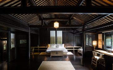 Amanfayun spa treatment room with dark timber ceiling, sunken bath, and warm lantern lighting.