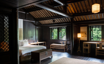 Principal bedroom at Amanfayun with timber ceiling, dark wood panelling, and traditional architectural details.