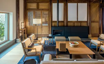 养云安缦度假村的宽敞起居室，配有木质屏风、蓝色沙发和简约家具。