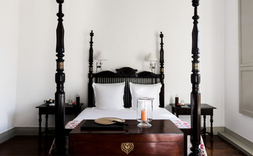 Principal bedroom at Amangalla with four-poster bed and crisp white linens.