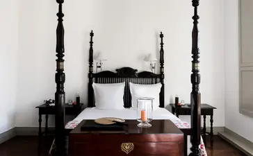 Principal bedroom at Amangalla with four-poster bed and crisp white linens.