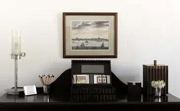 Principal bedroom desk at Amangalla with framed artwork and decorative objects.