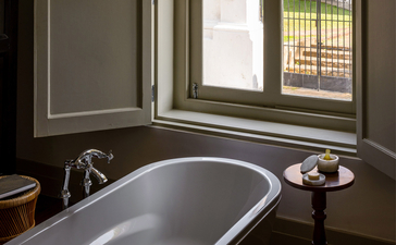 Principal bedroom bathroom at Amangalla with freestanding bathtub and window view.