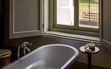 Principal bedroom bathroom at Amangalla with freestanding bathtub and window view.