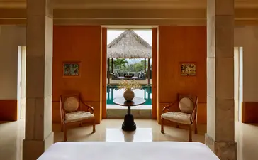 Borobudur Pool Suite at Amanjiwo resort with terracotta walls, stone columns, and views towards the temple.