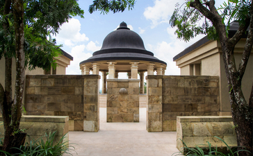 Dalem Jiwo Suite entrance pavilion at Amanjiwo, framed by stone walls and tropical foliage.