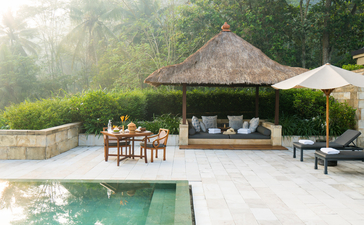 Dalem Jiwo Suite pavilion with thatched roof overlooking emerald plunge pool at Amanjiwo, Indonesia.