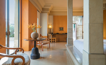 Dalem Jiwo Suite entrance at Amanjiwo, with stone columns and open-plan living areas beyond.