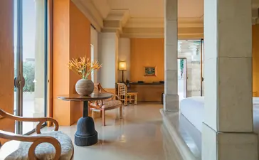 Dalem Jiwo Suite entrance at Amanjiwo, with stone columns and open-plan living areas beyond.