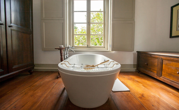 Garden Bedroom soaking tub at Amangalla, Sri Lanka, with wooden floors and garden views.