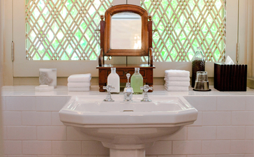 Circular basin with wooden mirror and toiletries at Amangalla, Sri Lanka.