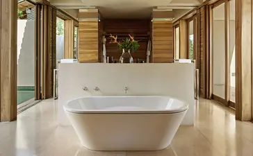 Garden Pool Suite bathroom at Amanwella with freestanding bath and doors opening to garden views.
