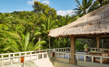 Amankila resort Garden Suite dengan pemandangan taman tropis dan atap rumbia tradisional.