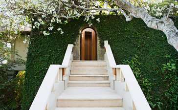 安缦丘澜度假村无边泳池套房的石阶通往木门入口，两侧绿植环绕。