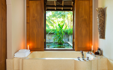 Infinity pool suite window overlooking tropical gardens at Amankila resort, Bali.