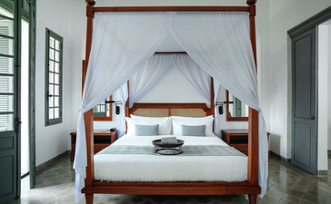 Principal bedroom with four-poster bed at Amantaka, Laos.