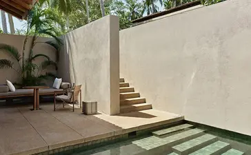 Ocean Pool Suite terrace with curved stone wall, stepped pathway, and tropical plants at Amanwella.