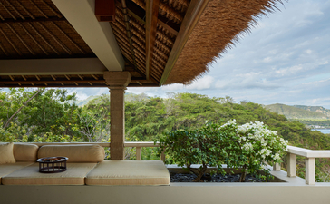 アマンキラのオーシャンスイートのテラスから、バリの緑豊かな丘陵地帯と海を望む眺め。