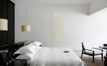 Principal bedroom with pool suite view at Amansara, Cambodia, featuring minimalist décor and black accent wall.